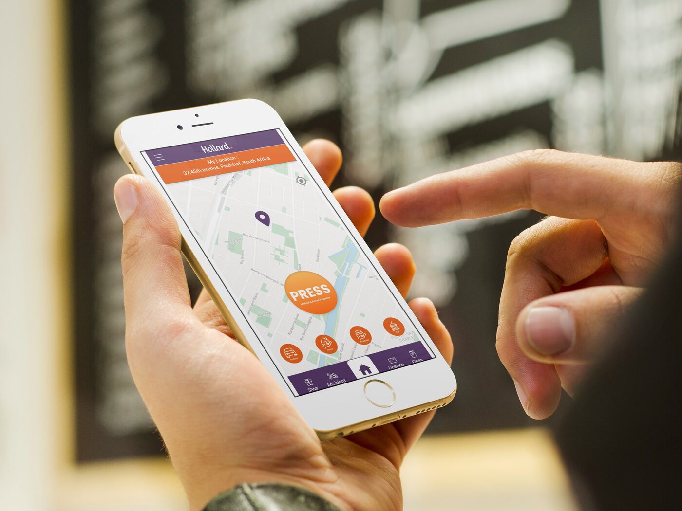 Hollard Help customer using the app on his iPhone at a train station